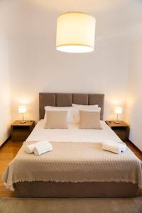 En eller flere senger på et rom på EntreVillas Alojamento Local, apartamento T2