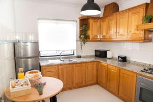 a kitchen with wooden cabinets and a small table at EntreVillas Alojamento Local, apartamento T2 in Arcos de Valdevez