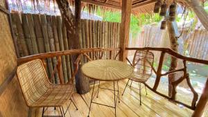 a table and two chairs on a porch at Monkey Business in Siquijor