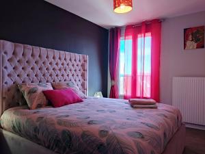 a bedroom with a large bed with a pink bedspread at Le Thourottois*Centre ville*Wifi*Spacieux*Confort* Saint-Gobain in Thourotte