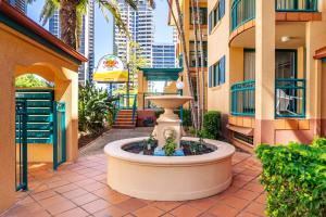 una fuente en medio de un patio con edificios en Aruba Sands Resort, en Gold Coast