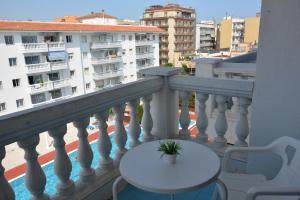 a white table and chairs on a balcony with buildings at APCOSTAS Europa in Blanes