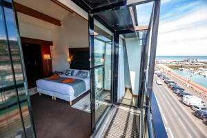 a hotel room with a bed and a view of a highway at Hotel Le Grand Pavois in Fécamp