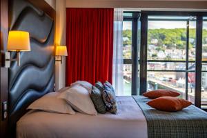 a bedroom with a large bed with a large window at Hotel Le Grand Pavois in Fécamp