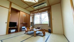 um quarto com uma mesa e cadeiras e uma janela em Tabinoyado Yakurai Rinsenkan em Osaki