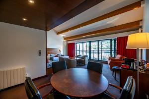 a living room with a wooden table and chairs at Hotel Le Grand Pavois in Fécamp