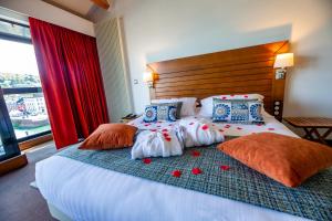 a bedroom with a large bed with red roses on it at Hotel Le Grand Pavois in Fécamp