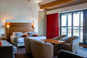 a hotel room with two beds and a table and chairs at Hotel Le Grand Pavois in Fécamp
