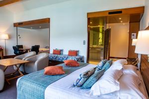 a hotel room with two beds and a living room at Hotel Le Grand Pavois in Fécamp
