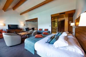 a bedroom with a large bed and a living room at Hotel Le Grand Pavois in Fécamp