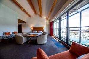 a living room with a table and chairs and windows at Hotel Le Grand Pavois in Fécamp