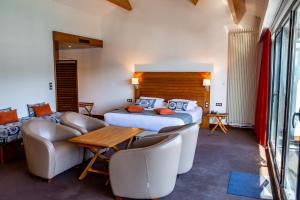 a hotel room with two beds and a table and chairs at Hotel Le Grand Pavois in Fécamp