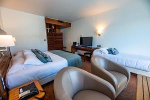 a hotel room with two beds and a desk at Hotel Le Grand Pavois in Fécamp