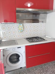 una cucina con piano cottura e lavatrice di Interno2 a Diano Marina