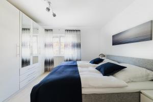 um quarto com uma cama grande com lençóis azuis e brancos em Ferienwohnung im Fischerhaus em Nonnenhorn