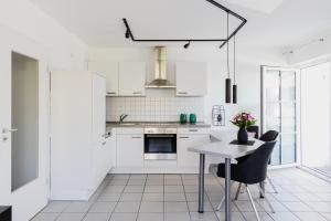 a kitchen with white cabinets and a table and chairs at Ferienwohnung im Fischerhaus in Nonnenhorn