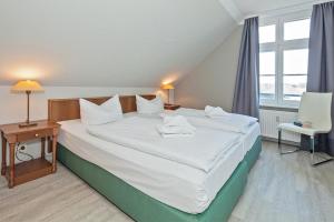 ein Schlafzimmer mit einem großen Bett mit weißer Bettwäsche in der Unterkunft Seehof Seehof 31 in Bansin