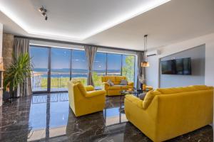 ein Wohnzimmer mit gelben Stühlen und einem TV in der Unterkunft Villa Anna - Kroatien - Crikvenica Riviera in Jadranovo
