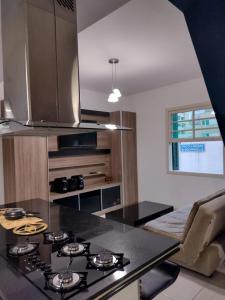 a kitchen with a black counter top and a stove at Apartamento no coração de Poços de Caldas in Poços de Caldas