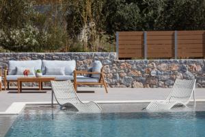 two chairs sitting next to a swimming pool at TreeTop Villa ΙΙ, outstanding spiritual retreat, By ThinkVilla in Loutra