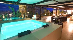 a large swimming pool in a room with a restaurant at Suite Hotel Santa Chiara in Lecce