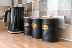 un grupo de tambores negros sentados junto a una cafetera en City Reach by Staytor Accommodation, en Exeter