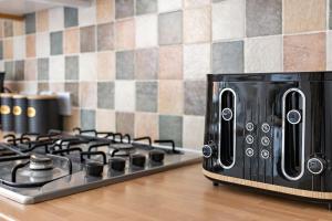 un horno tostador negro sobre una estufa en City Reach by Staytor Accommodation, en Exeter 17 fotos más