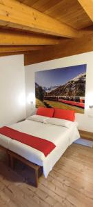 ティラーノにあるLe stanze del Trenino Rossoのベッドルーム1室(壁に絵画が描かれたベッド1台付)