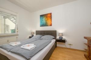 a bedroom with a large bed with two towels on it at Arbio I Local Apart in Sudvorstadt in Leipzig