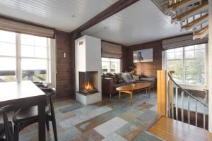 a living room with a fireplace and a couch at Mosetertoppen Panorama, Anneks 2B - Hafjell in Hafjell