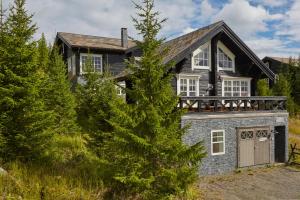 a stone house with a porch and a balcony at Mosetertoppen Panorama, Anneks 2B - Hafjell in Hafjell