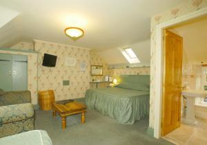 a bedroom with a bed and a chair and a sink at The Stables in Corwen