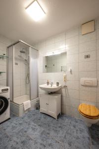 a bathroom with a sink and a shower and a toilet at Arbio I Local Apart in Sudvorstadt in Leipzig
