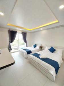 um quarto com duas camas e uma mesa em Vi An Hotel em Ho Chi Minh
