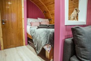 a room with a bed in a pink room at Fulshaw Mill Holidays in Stewarton