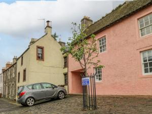 a car parked in front of a pink building at The Wee Hideaway in Cupar