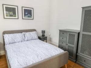 a bedroom with a bed and a dresser at Ramsey Cottage in Haverfordwest