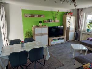 uma sala de estar com uma mesa e uma parede verde em Boutique-Apartment-Scherer em Duisburg