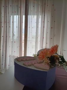een tafel met roze schoenen en bloemen erop bij Butterfly House in Castellammare di Stabia