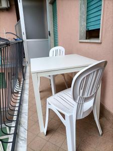 een witte tafel en twee witte stoelen naast een deur bij Butterfly House in Castellammare di Stabia
