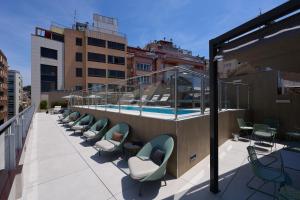 a balcony with chairs and a swimming pool on a building at Catalonia Barcelona 505 in Barcelona