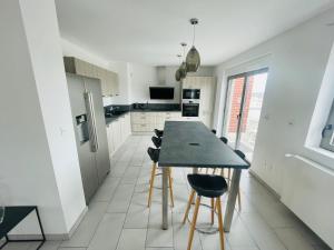 une cuisine avec une table et des chaises dans une pièce dans l'établissement VUE MER INCROYABLE - 3 Chambres - PARKING 2 PLACES - WIFI, à Berck-sur-Mer