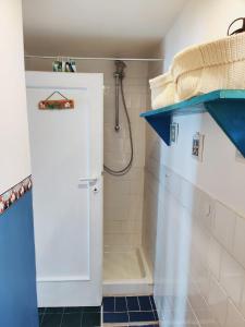 baño con ducha y puerta blanca en CasaAzul, en Sperlonga