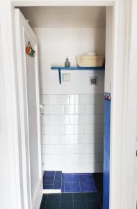 y baño con ducha de azulejos azules y blancos. en CasaAzul, en Sperlonga