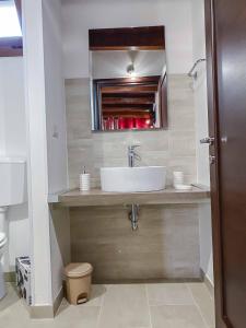 bagno con lavandino e specchio di Aparthotel Cortellenica a Torre San Giovanni Ugento