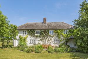 Ein altes weißes Haus mit Efeu drauf. in der Unterkunft Creaky Cottage in Dorchester