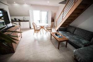 a living room with a couch and a table at APPART-DUPLEX VUE MER PANORAMIQUE BALCON & PISCINE proche commerce in Penmarcʼh