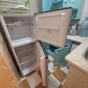 - un réfrigérateur ouvert avec une porte ouverte dans la cuisine dans l'établissement Coral flat with 2 bedrooms and 3 balconies ., à Marsa Alam