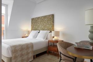 Habitación de hotel con cama, escritorio y mesa. en Zubieta Playa 3 by FeelFree Rentals, en San Sebastián