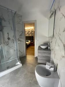 ein Bad mit einer Dusche, einem WC und einem Waschbecken in der Unterkunft Bike Hotel Touring Gardone Riviera & Beach in Gardone Riviera